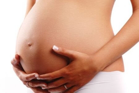 femme enceinte tenant son ventre à deux mains
